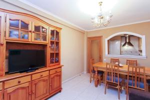 a dining room with a television and a dining table at Carlos V Planetcostadorada in Salou