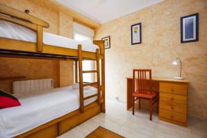 Un dormitorio con dos literas y un escritorio. en Egeo Only Families Planetcostadorada, en La Pineda 19 fotos más