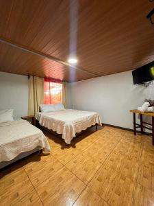 a room with two beds and a television in it at Sueños de Oro Corcovado in Sándalo +22 photos