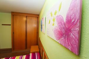 a bedroom with a pink butterfly painting on the wall at Mexico Planetcostadorada in Vilafortuny
