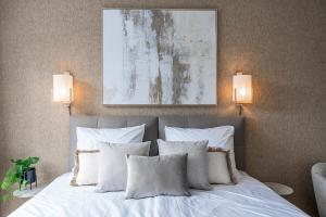 a bedroom with a bed with white pillows and a painting at New Bed-room, Nature Location,university Tilburg in Tilburg