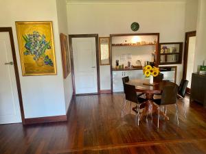 a dining room with a table and chairs and a kitchen at Sandalwood Downs Fabulous Farm Stay TOODYAY in Toodyay