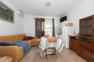 a living room with a couch and a table and chairs at Apartments Zamicka in Brela