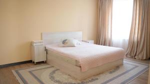 a bedroom with a bed and a window at Royal Pool Cottage in Shymkent