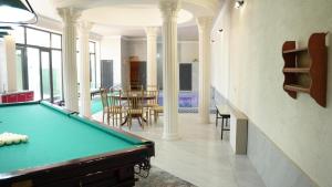 a room with a pool table and a dining room at Royal Pool Cottage in Shymkent