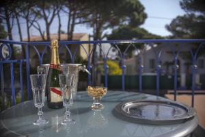 a table with a bottle of champagne and two glasses at Hôtel Le Méditerranée in Hyères