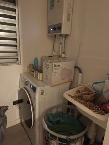 - une buanderie avec un lave-linge et une boîte dans l'établissement Arriendo departamento amoblado por día, à Villa Alemana 2 autres photos