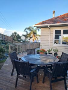 a patio with a table and chairs on a deck at Pukenui Gem in Pukenui