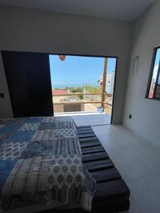 ein Schlafzimmer mit einem Bett und einem großen Fenster in der Unterkunft Taiba House in São Gonçalo do Amarante + 17 Fotos