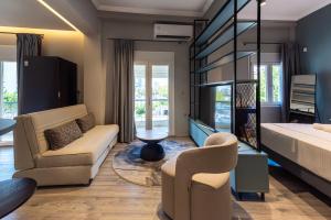 テッサロニキにあるMondeus Inn Luxury Suites Δ1 & Δ2のリビングルーム(ベッド1台、ソファ、椅子付)