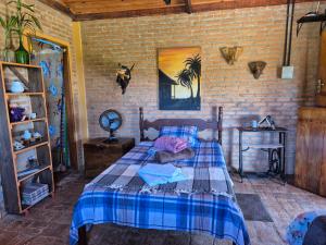 a bedroom with a bed and a brick wall at Chalés Mirante da Serra in São Thomé das Letras