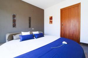 una camera da letto con un letto grande con cuscini blu di Dream Planetcostadorada a Salou Altre 31 foto
