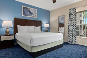 a bedroom with a large white bed and a window at Club Wyndham Cypress Palms in Kissimmee