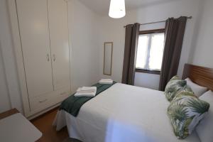 a bedroom with a white bed and a window at Quinta da Bouça - Casa das Cangas in Vale de Cambra +5 photos