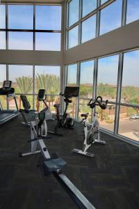 una palestra con tapis roulant ed ellittiche in una stanza con finestre di 2Bedrooms Lakeview Loft Walk to Mill Ave and ASU a Tempe