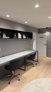 an office with a desk and two chairs in a room at Loft Moderno no Centro de Blumenau in Blumenau