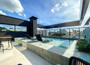 a balcony with a swimming pool on top of a building at Loft Moderno no Centro de Blumenau in Blumenau