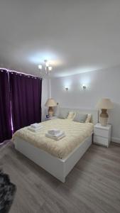 a bedroom with a large white bed with two lamps at The Skyline in Reading