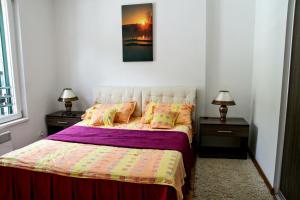 1 dormitorio con 1 cama con 2 mesitas de noche y 2 lámparas en Apartment Royal Savina-free garage, en Herceg-Novi