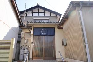 a building with a large door with birds on it at のまちのスミカ 宿 Nomachi Sumika in Kanazawa