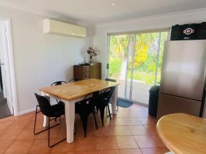 a kitchen with a table and chairs and a refrigerator at 6 Wrights Close, Mallacoota in Mallacoota