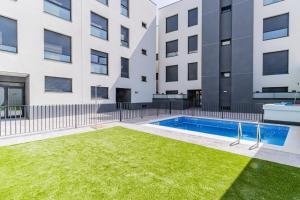 an apartment with a swimming pool in front of a building at Suite Zaragoza - Severo Ochoa in Villanueva de Gállego