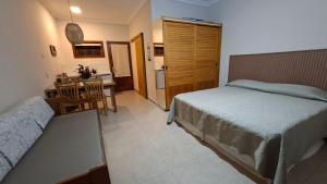 Un dormitorio con una cama y una mesa y una cocina. en FLAT ILHA FLAT HOTEL, en Ilhabela 16 fotos más