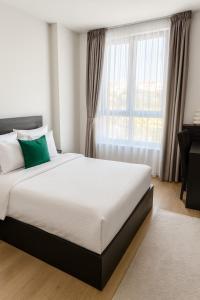 un lit dans une chambre avec une grande fenêtre dans l'établissement ForS Belgrade Waterfront, à Belgrade