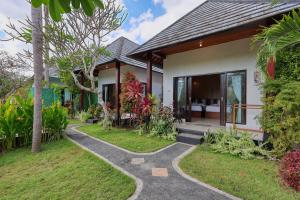 a villa with a garden and a walkway at WK Penida Cottage in Nusa Penida