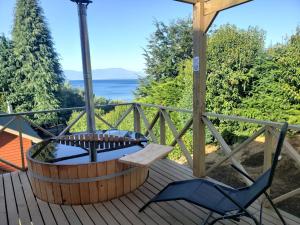 a wooden deck with a table and chairs on it at Ranco Lodge in Ranco