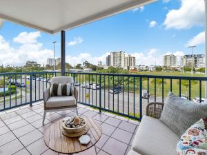 ein Wohnzimmer mit Balkon mit Couch und Tisch in der Unterkunft Sea Shapes Coastal Escape 3 Bed Apartment in Maroochydore