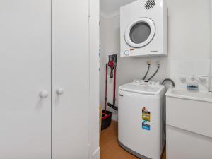 ein Badezimmer mit Waschmaschine und Waschmaschine in der Unterkunft Sea Shapes Coastal Escape 3 Bed Apartment in Maroochydore
