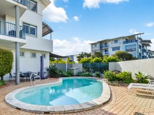 einem Pool vor einem Apartmentgebäude in der Unterkunft Sea Shapes Coastal Escape 3 Bed Apartment in Maroochydore