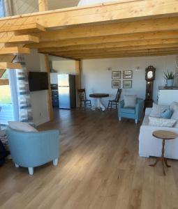 a large living room with blue couches and a clock at Luxury oceanfront escape in Neguac