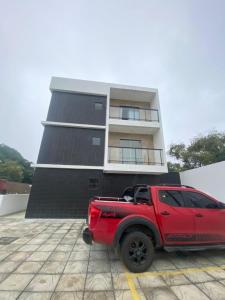 a red truck parked in front of a building at Apartamento Praia Carapibus in Conde