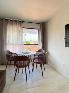 a living room with a table and chairs and a window at Apartamento Praia Carapibus in Conde