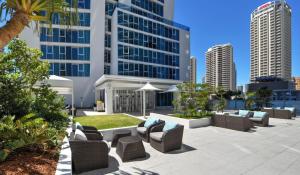 un patio con sofás y sillas frente a edificios altos en Level 15 - Hilton Surfers Paradise, en Gold Coast