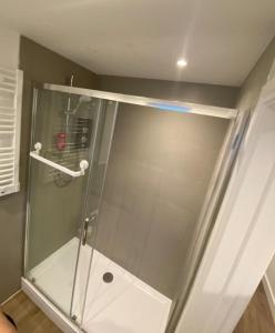 a shower with a glass door in a bathroom at Stylish Detached Studio, Banstead with off street Parking in Banstead +9 photos