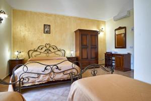 een slaapkamer met een bed en een dressoir bij Agriturismo Conte Ruggero in Centuripe