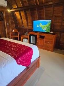 ein Schlafzimmer mit einem Bett und einem Flachbildfernseher in der Unterkunft Dudu Cottage Nusa Penida in Nusa Penida + 25 Fotos