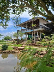a house with a river in front of it at Black Bears Resort & Onsen in Ban Thung Lakhon