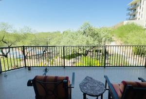 ein Balkon mit Stühlen und einem Tisch und einem Zaun in der Unterkunft Luxurious 3 BR & 3 BA Condo with Spectacular Views in Fountain Hills