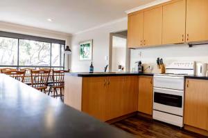 a kitchen with wooden cabinets and a counter top at Allure " Absolute Waterfront " Family Friendly in Bicheno