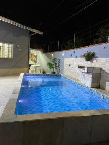 a large blue swimming pool in a building at Casa com piscina climatizada em Itanhaém! in Itanhaém +27 photos