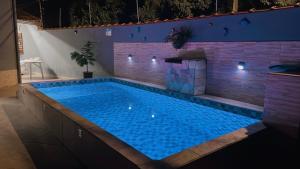 a large swimming pool in a house at night at Casa com piscina climatizada em Itanhaém! in Itanhaém