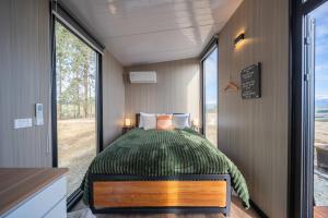 a bedroom in a tiny house with a bed at Whitestone Retreat X by Tiny Away in The Key