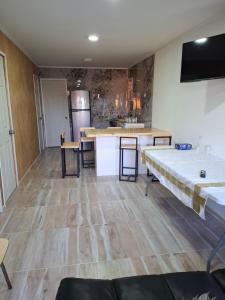 a large room with a kitchen and a table at Cabaña caldera centro in Caldera +3 photos