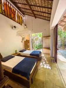 a bedroom with two beds and a window at Pousada Castelo Do Vento in Prea +84 photos