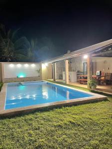 a swimming pool in front of a house at night at Casa Paraiso in Beberibe