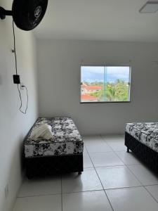a room with two beds and a window at Casa Paraiso in Beberibe